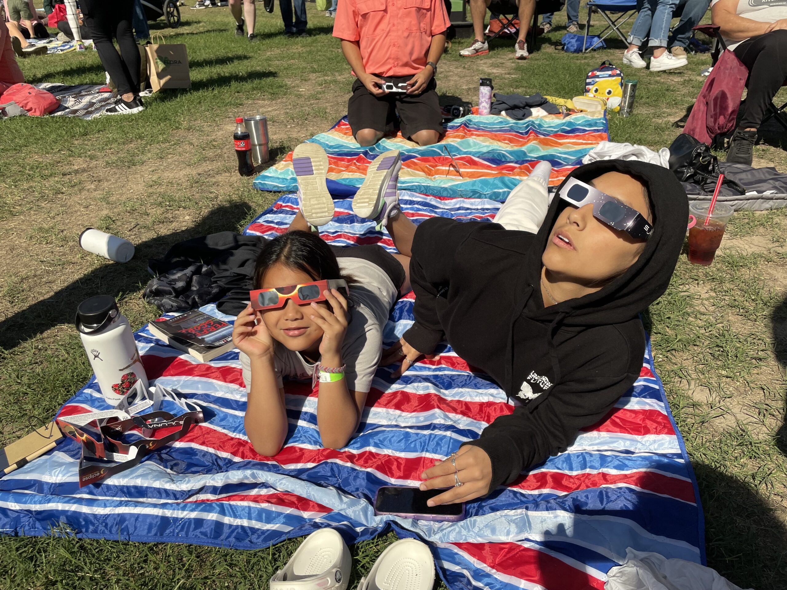 Pessoas utilizando óculos de proteção apropriados para observar um eclipse solar.